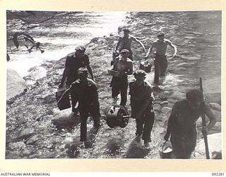 BOUGAINVILLE. 1945-05-17. SIGNALMEN LAYING CABLE ACROSS THE HONGORAI RIVER AT DURHAM'S CROSSING DURING THE C COMPANY, 57/60 INFANTRY BATTALION ADVANCE ALONG COMMANDO ROAD. ALSO, A FRONT VIEW OF ..