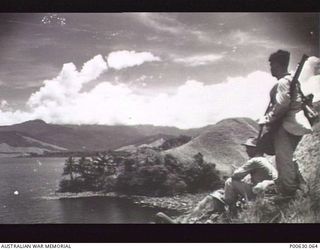 NADZAB, NEW GUINEA, C 1945. A GROUP OF SOLDIERS LOOKING OVER THE LAKE AT NADZAB (DONOR: MUSEUMS AND ART GALLERIES OF THE N.T.)
