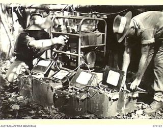 KILIGIA, NEW GUINEA. 1944-03-12. QX57857 SIGNALMAN J.V. DAVIDSON (1), WITH QX55519 SIGNALMAN J.W.P. CRISFORD (2), CHARGING BATTERIES WITH AN "ONAN" 1260 WATT BATTERY CHARGING UNIT AT HEADQUARTERS, ..