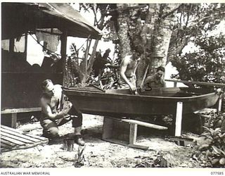 PERSONNEL OF NO. 6 PLATOON, 27TH INFANTRY BATTALION PUTTING THE FINISHING TOUCHES TO A FISHING DINGHY. IDENTIFIED PERSONNEL ARE:- NX132330 PRIVATE H.H. HUTCHINS (1); V509003 PRIVATE W.G. FRENCH ..