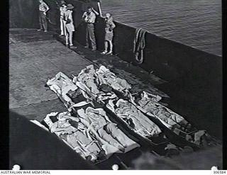 PELELIU, PACIFIC OCEAN. 1945-07. A LANDING CRAFT FERRIES A NUMBER OF INJURED SURVIVORS OF THE CRUISER USS INDIANAPOLIS ON STRETCHERS TO THE SHORE FOR HOSPITALISATION. THE INDIANAPOLIS WAS SUNK BY A ..