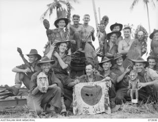 ALEXISHAFEN, NEW GUINEA. 1944-04-30. MEMBERS OF THE 30TH INFANTRY BATTALION DISPLAYING NATIVE CARVINGS AND A CAPTURED JAPANESE FLAG FOUND IN THE AREA. IDENTIFIED PERSONNEL ARE:- WARRANT OFFICER II, ..