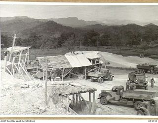 PORT MORESBY, NEW GUINEA. 1943-06-26. GENERAL VIEW OF THE CRUSHING BATTERY AT THE NINE MILE QUARRY WITH TRANSPORT IN FOREGROUND. THE PLANT AND MECHANICAL EQUIPMENT USED IS THE PROPERTY OF THE ..