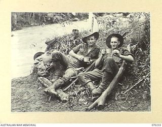 FARIA VALLEY, NEW GUINEA. 1944-02-10. QX34268 PRIVATE F.J. WALTON (1); AND QX34162 PRIVATE H.B. PROSSER (2); MEMBERS OF THE 2/10TH INFANTRY BATTALION, PICTURED RESTING ON THE BANK AT MAIN STREAM