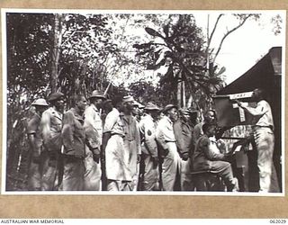 DREGER HARBOUR, NEW GUINEA. 1943-12-06. CHAPLAIN WARREN J. JENKINS OF ATLANTA, GEORGIA, CHAPLAIN OF THE 870TH UNITED STATES AVIATION ENGINEER BATTALION, CONDUCTING CHOIR PRACTICE, WHILE CORPORAL ..