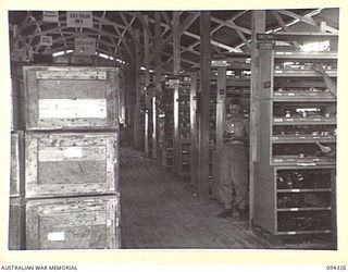 TOROKINA, BOUGAINVILLE. 1945-07-25. PRIVATE R.A. WILSON, AT WORK IN THE DETAILS ISSUE ENGINEERS STORES, ONE OF THE STORAGE SHEDS AT 16 ADVANCED ORDNANCE DEPOT