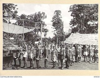 MOROKAIMORO, BOUGAINVILLE, 1945-06-06. PERSONNEL QUEUEING UP FOR MESS AT HQ, 2/8 COMMANDO SQUADRON. LONG RANGE PATROLS OPERATE FROM THIS UNIT CARRYING OUT HARRASSING RAIDS AND AMBUSHES AGAINST THE ..