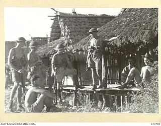 AUSTRALIAN TROOPS OUTSIDE THEIR BILLETS SOMEWHERE IN NEW GUINEA