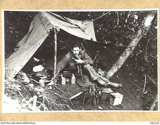 FARIA RIVER AREA, NEW GUINEA. 1943-11-07. SX2668 LIEUTENANT G.A. KING OF NO. 15 PLATOON, C COMPANY, 2/27TH AUSTRALIAN INFANTRY BATTALION, IN HIS TENT ON SHAGGY RIDGE