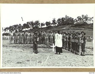 BOMANA WAR CEMETERY, PAPUA, NEW GUINEA. 1943-12-29. CHAPLAIN J. D. MCKIE, CHURCH OF ENGLAND, CONDUCTING A GRAVESIDE MEMORIAL SERVICE FOR PENDIL A. RAYNER, AN AUSTRALIAN WAR CORRESPONDENT, WHO WAS ..