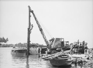 MILILAT, NEW GUINEA. 1944-08-22. ENGINEERS OF HEADQUARTERS, 5TH DIVISION PUTTING A MOBILE PILE DRIVER INTO ACTION DURING THE CONSTRUCTION OF A NEW JETTY