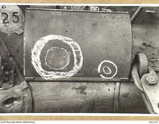 SCARLET BEACH AREA, NEW GUINEA. 1943-12-21. DRIVER'S COVER OF A MATILDA TANK SHOWING THE EFFECTS OF A JAPANESE MAGNETIC BOMB (LARGE CIRCLE) AND 37MM SHELL (SMALL CIRCLE) AT THE 1ST AUSTRALIAN TANK ..