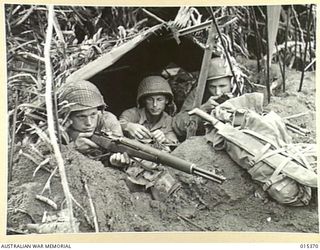 1943-07-31. ALLIED CAPTURE OF MUBO. AN AMERICAN OUTPOST AT NASSAU BAY. LEFT TO RIGHT: PTE. HARRY EMMACK, OF LONG BEACH, CAL. FIRST CLASS PTE. FLOYD CHAMBERS OF LONG BEACH, FIRST CLASS PTE. HOWARD ..