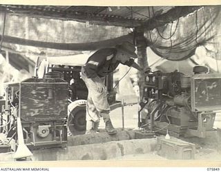 ALEXISHAFEN, NEW GUINEA. 1944-09-13. VX248 MAJOR S.E. SAMUELS, COMMANDING OFFICER, INSPECTING THE WORKSHOP POWER PLANT AT THE 133RD BRIGADE WORKSHOPS