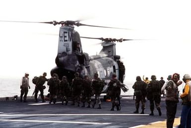 Marines on the flight deck of the amphibious assault ship USS SAIPAN (LHA-2) board a CH-46E Sea Knight helicopter from Marine Medium Helicopter Squadron 261 (HMM-261) for transportation to Monrovia, Liberia, to evacuate dependents and non-essential U.S. Embassy staff from the midst of fighting between Liberian government forces and rebel factions