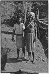 Two men by fence, drainage ditch on right