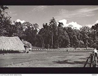 SOPUTA, NEW GUINEA, 1943-07-20. SOPUTA WAR CEMETERY, WITH THE 15TH AUSTRALIAN WAR GRAVES REGISTER AND ENQUIRY UNIT HUT ON THE LEFT. AUSTRALIANS WHO WERE KILLED AT SANANANDA, KILLERTON, SOPUTA AND ..