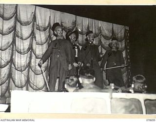 BOUGAINVILLE ISLAND. 1945-01-27. MEMBERS OF THE 58/59TH INFANTRY BATTALION PLAYERS STAGING A BURLESQUE ACT DURING A CONCERT STAGED AT THE 2ND AUSTRALIAN CORPS HEADQUARTERS. IDENTIFIED PERSONNEL ..