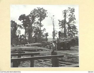 BUSU FOREST, LAE AREA, NEW GUINEA. 1944-07-26. A SAWN PLANK BEING REMOVED FROM THE OUTPUT SKIDS TO THE STACK AT THE 2/3RD FORESTRY COMPANY, ROYAL AUSTRALIAN ENGINEERS