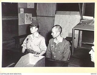 TOROKINA, BOUGAINVILLE, 1945-08-20. CAPTAIN TAKENAKA (1), ENVOY FROM LIEUTENANT-GENERAL M. KANDA, COMMANDER 17 JAPANESE ARMY GROUP, WITH HIS CIVILIAN INTERPRETER, MR TAKAHASHI (2), DURING SURRENDER ..