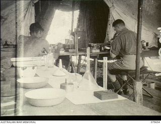 Oro Bay, New Guinea. 1943-05. VX104013 Major I. A. Wilson (right) at a microscope in the pathology tent at the Main Dressing Station, 10th Field Ambulance, Australian Army Medical Corps