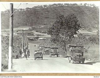 FOUR MILE VALLEY, PAPUA, NEW GUINEA. 1944-01-02. A VIEW OF THE MAIN PORT MORESBY ROAD AT FOUR MILE VALLEY, SHOWING TRAFFIC CONTROL POINT AND NATIVES WAITING FOR A LIFT