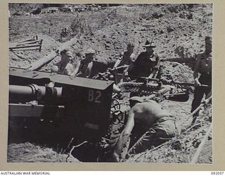 BOUGAINVILLE. 1945-05-16. GUNNERS OF 21 BATTERY, 2/11 FIELD REGIMENT, ROYAL AUSTRALIAN ARMY, MANHANDLING A 25 POUNDER, WITH THE AID OF DRAG ROPES, INTO POSITION OVER GUN PLATFORM. THE NEW GUN PITS ..