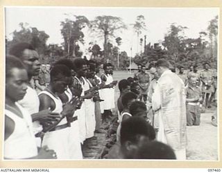 TOROKINA, BOUGAINVILLE. 1945-10-03. NATIVES RECEIVING HOLY COMMUNION AT THE SOLEMN HIGH MASS OF THANKSGIVING FOR PEACE HELD AT GLOUCESTER PARK OVAL. TROOPS OF HEADQUARTERS 3 DIVISION WERE AMONG THE ..