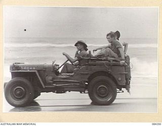 SUAIN PLANTATION, NEW GUINEA. 1944-12-10. A JEEP CARRYING RAAF PERSONNEL MAKES USE OF THE HARD SOIL DURING LOW TIDE TO TRANSPORT URGENT SUPPLIES TO SUAIN PLANTATION FROM BABIANG