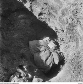 SOPUTA, NEW GUINEA. 1944-06-14/02. REMAINS OF AUSTRALIAN SOLDIERS, BROUGHT FROM CAPE ENDAIADERE BY MEMBERS OF THE 7TH GRAVES REGISTRATION UNIT, BEING INTERRED IN THE WAR CEMETERY