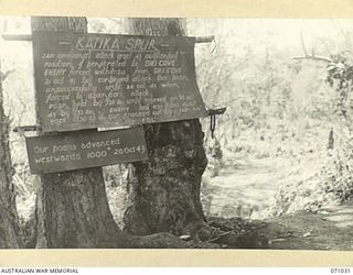 KATIKA SPUR, FINSCHHAFEN AREA, NEW GUINEA. 1944-03-13. ONE OF MANY BATTLE SIGNS IN THE FINSCHHAFEN AREA, THIS SIGN RECORDS ACTIVITIES OF THE 2/28TH AND 2/32ND INFANTRY BATTALIONS