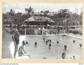 LAE, NEW GUINEA. 1945-10-20. AUSTRALIAN WOMEN'S ARMY SERVICE AND TROOPS OF FIRST ARMY ENJOYING A DIP IN THE AUSTRALIAN NEW GUINEA ADMINISTRATIVE UNIT SWIMMING POOL. WATER FOR THE POOL IS SUPPLIED ..