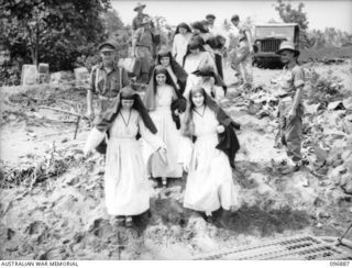 Sisters and Priests boarding an Army barge for transfer to the motor launch Gloria. They are being evacuated from the Mission in Ramale Valley to Rabaul. Contact with the internees was made by ..