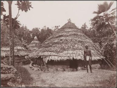 A man standing in front of a round house at Te Motu, Santa Cruz Islands, 1906 / J.W. Beattie