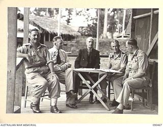 LAE, NEW GUINEA. 1945-04-08. SENATOR J.M. FRASER, ACTING MINISTER FOR THE ARMY (3), WITH SENIOR OFFICERS ON THE VERANDAH OF THE GENERAL OFFICER COMMANDING'S HUT, HEADQUARTERS FIRST ARMY. IDENTIFIED ..