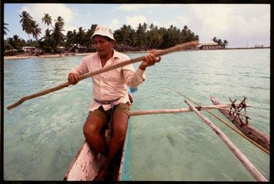 Man in outrigger canoe, Cook Islands