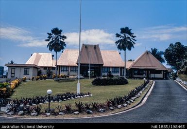 Fiji - complex of three red-roofed buildings, Fijian flag in front