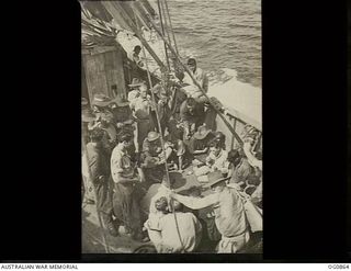 AT SEA BETWEEN GOODENOUGH ISLAND AND THE TROBRIAND ISLANDS, PAPUA. 1943-11-27. AIRMEN OF NOS. 22 AND 30 SQUADRONS RAAF STARTED A GAME OF DICE ON DECK TO PASS AWAY THE TIME ABOARD THE SS HANYANG ..