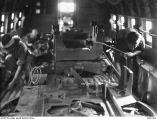 WARD'S DROME, NEW GUINEA. 1943-11-16. TROOPS OF THE 2/5TH AUSTRALIAN FIELD REGIMENT, 7TH AUSTRALIAN DIVISION, LASHING THE PARTS OF A LONG 25-POUNDER GUN IN A DOUGLAS TRANSPORT AIRCRAFT, DURING AN ..