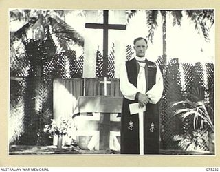 NORTH ALEXISHAFEN, NEW GUINEA. 1944-08-10. VX20306 CHAPLAIN GENERAL C.L. RILEY, CBE, VD, BISHOP OF BENDIGO, VICTORIA, HEADQUARTERS, NEW GUINEA FORCE, STANDING AT THE ALTAR OF THE OPEN AIR JUNGLE ..