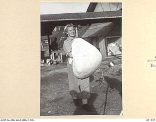 BOUGAINVILLE, 1945-04-18. PRIVATE R.B. RIGBY, AUSTRALIAN ARMY MEDICAL WOMEN'S SERVICE, DOING THE DAILY SORTING OF SOILED LINEN FROM THE WARDS OF 2/1 GENERAL HOSPITAL