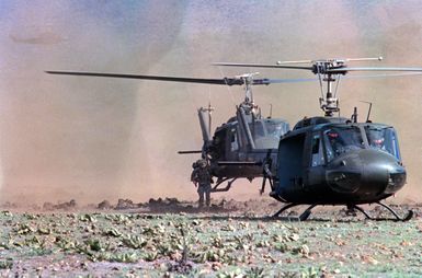 UH-1A Iroquois helicopters from the 25th Combat Aviation Battalion arrive at a landing zone carrying members of the 2nd Brigade, 25th Infantry Division. The troops are conducting an airmobile assault during training Exercise OPPORTUNE JOURNEY 4-83. (SUBST