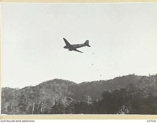 PAPUA, NEW GUINEA. 1942-10. TRANSPORT PLANE OF THE UNITED STATES AIR FORCE DROPPING FOOD SUPPLIES ON A CLEARED SPACE AT NAURO VILLAGE DURING THE ADVANCE OF THE 25TH AUSTRALIAN INFANTRY BRIGADE OVER ..