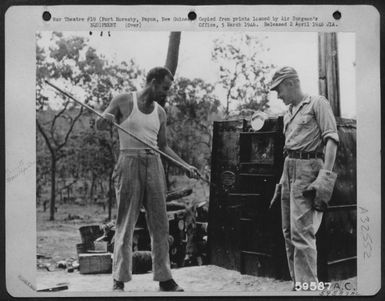 Taking hot rolls from the oven of the 38th Bomb Group, 822nd Bomb Squadron, at Port Moresby, Papua, New Guinea Sept. 1943. (U.S. Air Force Number 59587AC)