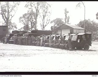 TOROKINA, BOUGAINVILLE, 1945-12-03. MEMBERS OF 1 DETACHMENT MOBILE CINEMA UNIT, LINED UP BESIDE THEIR VEHICLES AT BOSLEY FIELD, WHICH WAS TAKEN OVER FROM THE AMERICANS AND IS THE LARGEST THEATRE ..