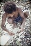 Canoe-building: man carves nipawa (grasshopper) design on prow