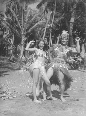 [Pacific Island man and woman in grass skirts]