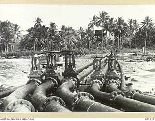 MILNE BAY, PAPUA, NEW GUINEA. 1944-04-03. PIPE LINES LEADING FROM THE PIER AT THE 2ND BULK PETROLEUM STORAGE COMPANY. PETROL IS PUMPED DIRECTLY FROM OIL TANKERS TO STORAGE TANKS AT THE INSTALLATION