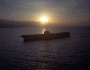 An aerial portside silhouette of the US Navy (USN) Forrestal Class Aircraft Carrier USS RANGER (CV 61), with her Sailors manning the rails and aircraft of the Carrier Air Wing 2 (CVW-2) on her deck, as she arrives at Pearl Harbor Naval Base in Pearl Harbor, Hawaii (HI)