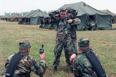 US Army (USA) Soldiers assigned to A/Company, 1ST Battalion, 17th Infantry Division practice search and control of suspect techniques near the tent city living facilities at Orote Point, Guam during Exercise TANDEM THRUST '99